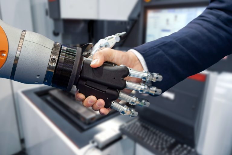 Hand of a businessman shaking hands with a Android robot.