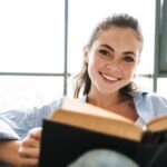 Happy positive girl reading book