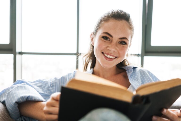 Happy positive girl reading book