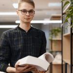 A student man picking books from the shelf