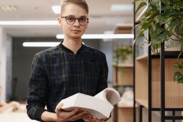 A student man picking books from the shelf