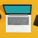 Laptop and smartphone on a bright yellow desk