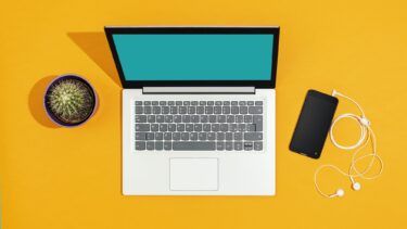 Laptop and smartphone on a bright yellow desk