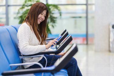 passenger holding and scanning mobile phone with qr code scanner machine of message chair